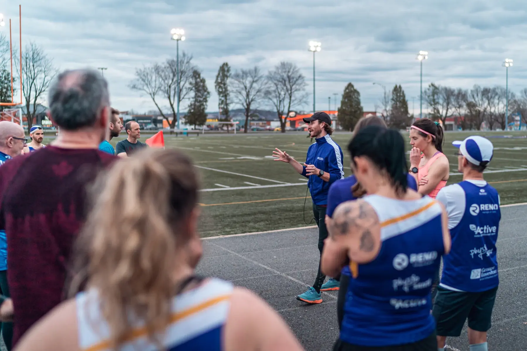 Un entraîneur présente la séance aux membres du Club Citius réunis sur la piste.